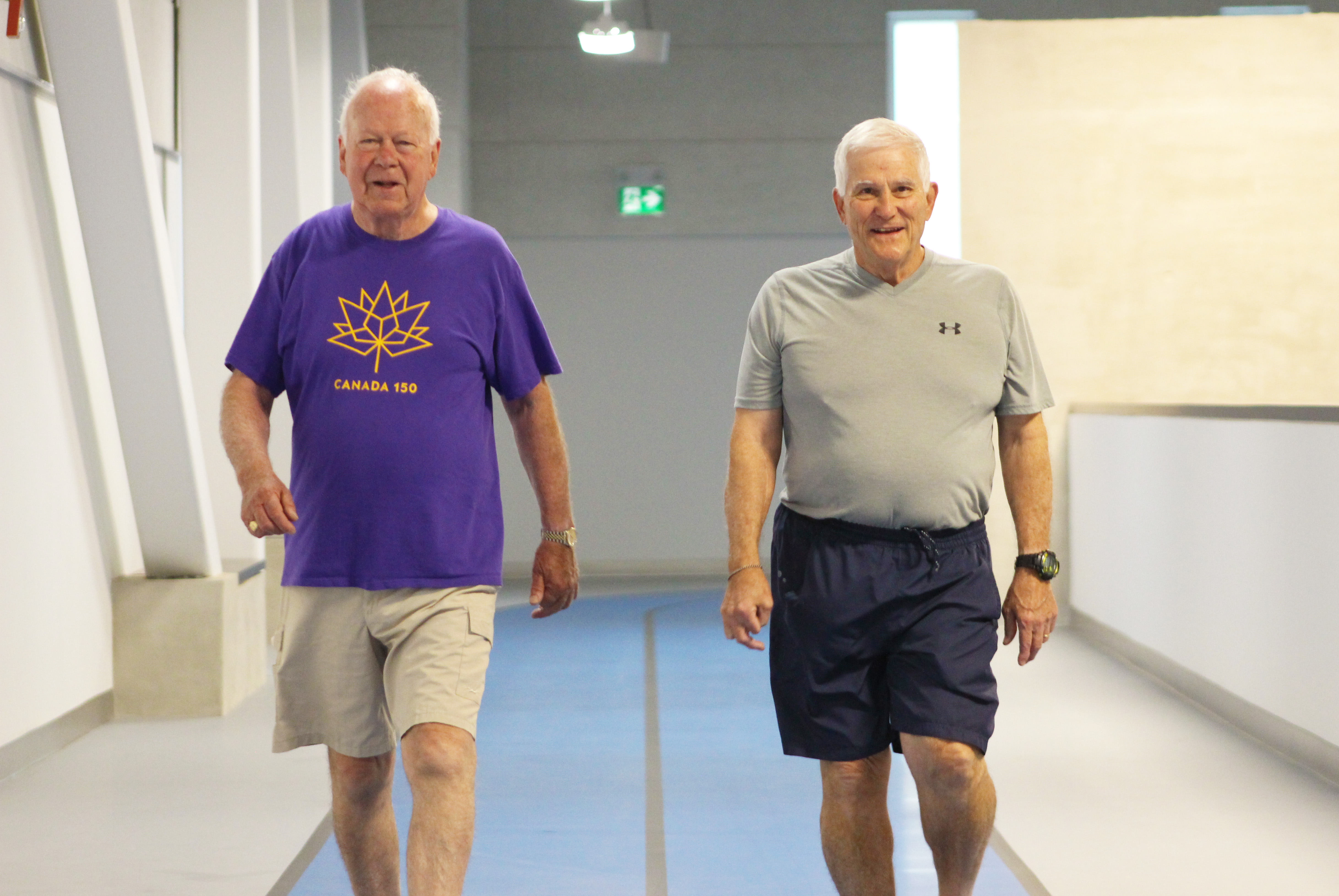 elderly men walking on indoor track