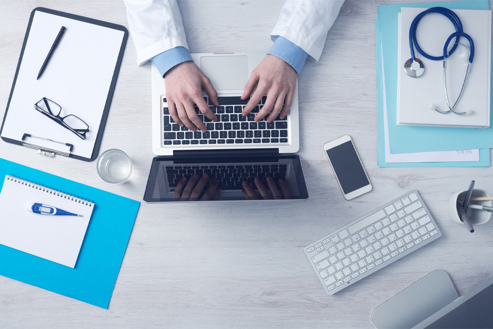 doctors hands typing laptop