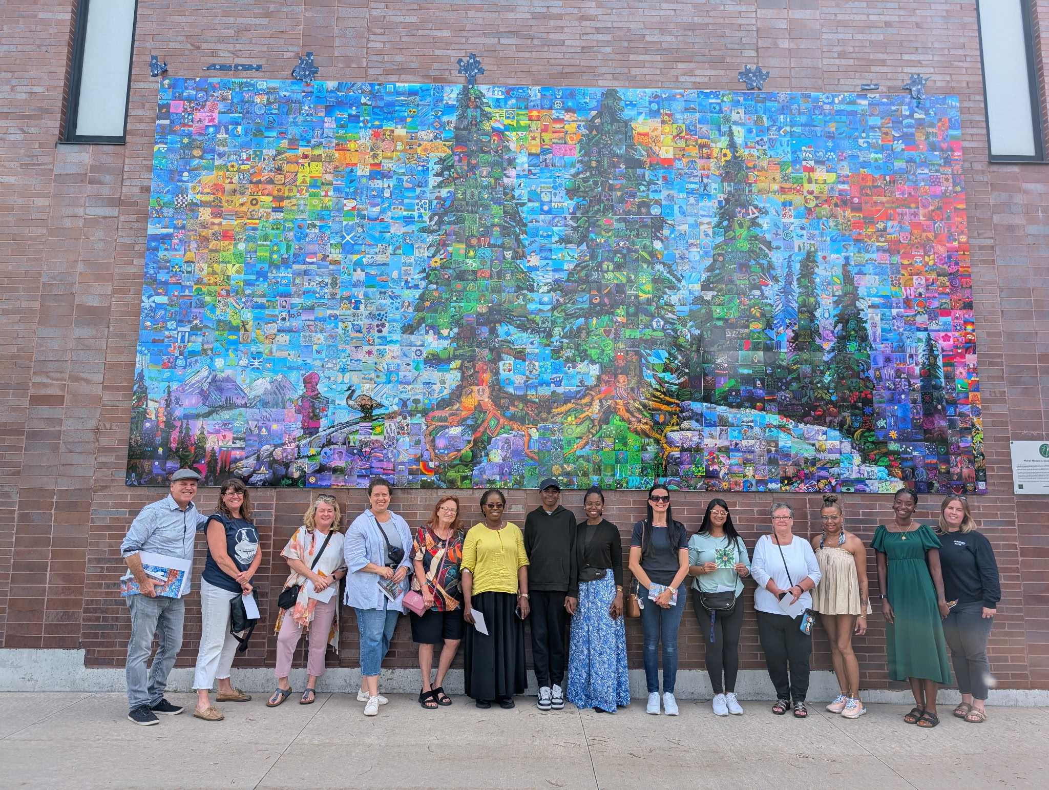 Group stands infront of displayed mural